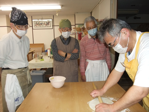 「二のし」の作業は、手のひらとめん棒を使い均等な厚さの生地となるようにのしていきます。